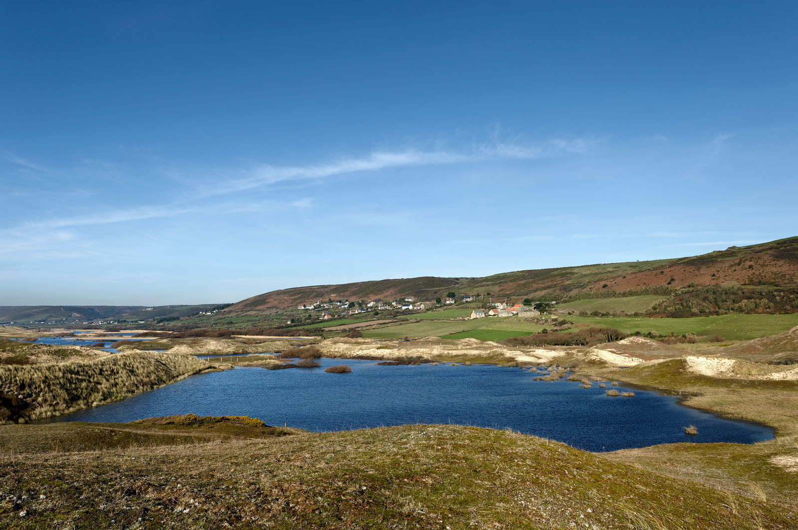 Le village de Vauville fait partie des sites classés de la Hague, Cap Cotentin. Les Pierres Pouquelées, galerie néolithique, sont un témoignage de l'Antiquité.La mare de Vauville est une réserve naturelle. Créée en 1976 c'est l'une des 135 réserves naturelles de France. Géré par le Groupe Ornithologique Normand depuis 1983, c'est un marais d'eau douce protégé de la mer par un étroit cordon dunaire. La mare de Vauville fait 62 ha, il y a plus de 150 espèces d'oiseaux ainsi que de 350 plantes et 16 espèces de batraciens.Un édifice autrefois religieux domine le village. C'est le prieuré de Vauville construit dans les landes, sur le haut d'une colline.Créé par Eric et Nicole Pellerin en 1947, l'exceptionnel jardin botanique du château de Vauville occupe plus de 40 000 m2. Abritant plus de 1000 espèces de l'hémisphère austral, le jardin entoure le château de Vauville dans une ambiance subtropicale tout à fait surprenante.